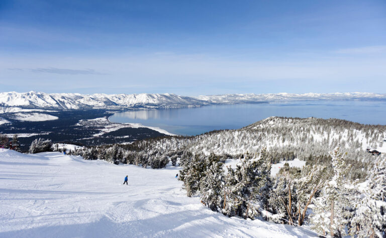 Esquiadores aproveitam as descidas com uma bela vista invernal de Lake Tahoe.