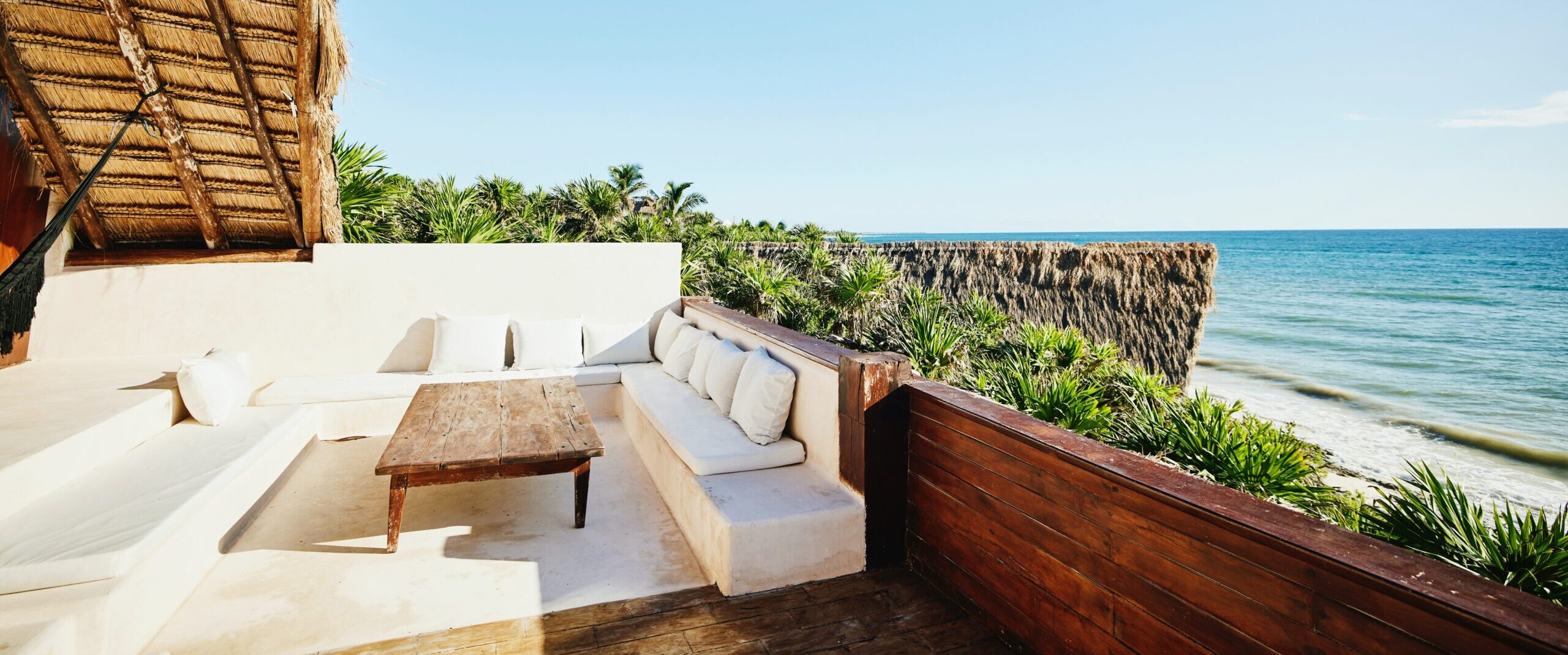 Foto ampla de uma área de estar sobre o deck de uma luxuosa suíte em um resort tropical