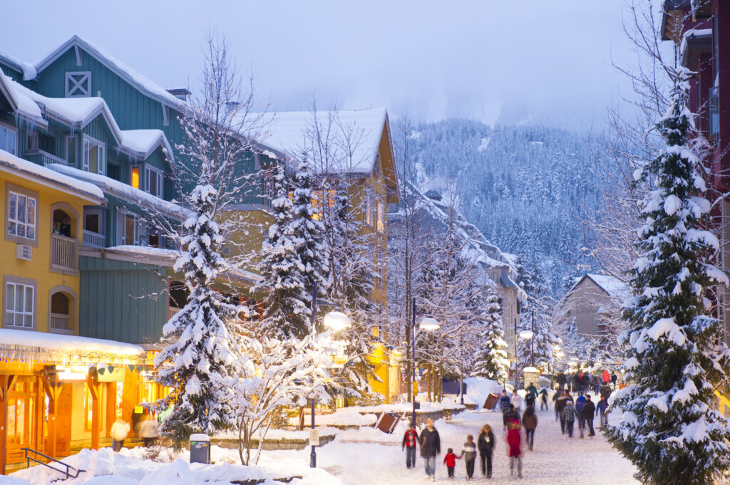A vila para pedestres de Whistler, repleta de lojas, hotéis e restaurantes cobertos de neve ao crepúsculo