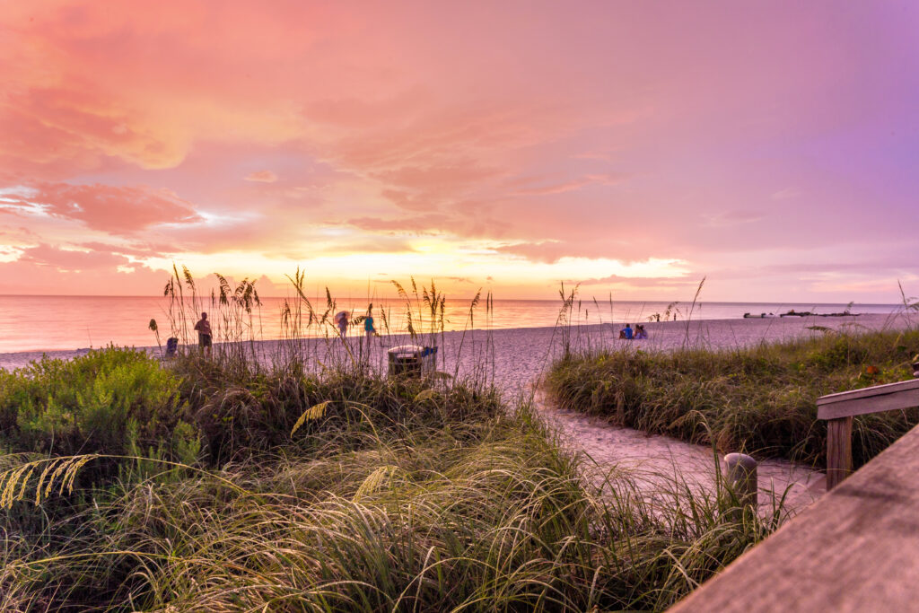 O sol se põe na praia em Naples, no Golfo do México, sudoeste da Flórida, EUA. Um lugar espetacular para apreciar o pôr-do-sol neste local perfeito para relaxar em férias com a família.
